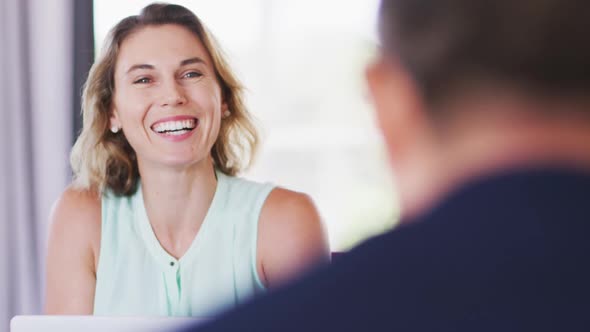 Professional businesswoman smiling while talking to her colleagues in modern office in slow motion