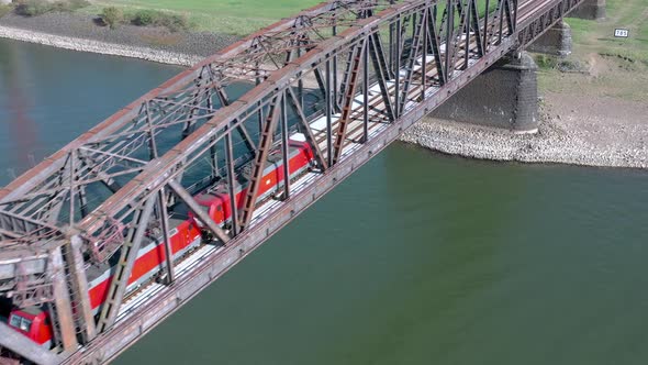 Freight Train Crossing an Iron Bridge Spanning a River