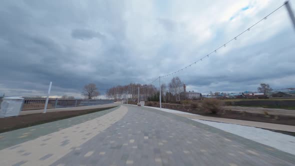Empty Road and Narrow Channel with Bridge Under Heavy Clouds