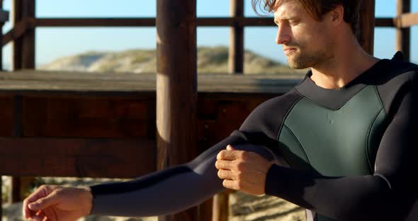 Male surfer wearing wetsuit in the beach 4k