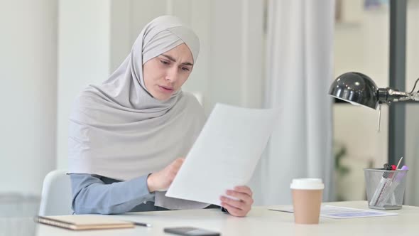 Young Arab Woman Reacting to Loss While Reading Documents