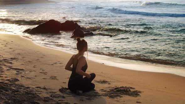 Wonderful Girl Sits in Relaxing Yoga Pose Backside View