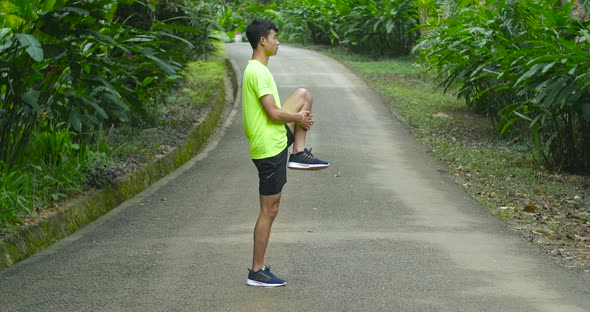 Man Stretching Legs On Road Before Run