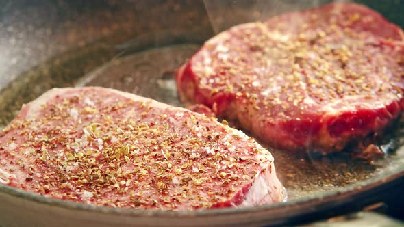 Two Pieces of Spiced Raw Steak are Panfried at Home