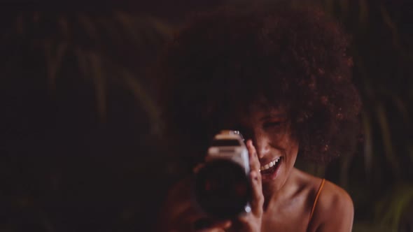 Woman With Afro Hair In Orange Dress Using Vintage 8Mm Camera