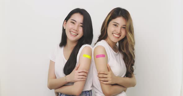 Smiling Asian Women Show Bandage On Arm. Happy Asian Woman Feels Good After Received Vaccine.