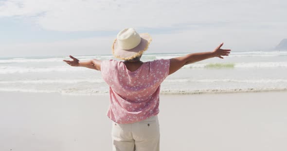 Mixed race senior woman spinning with open hands at the beach