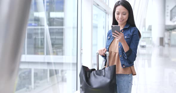 Woman looking at cellphone in airport