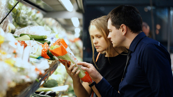 Man And Woman Buying Fresh Vegetables In Grocery