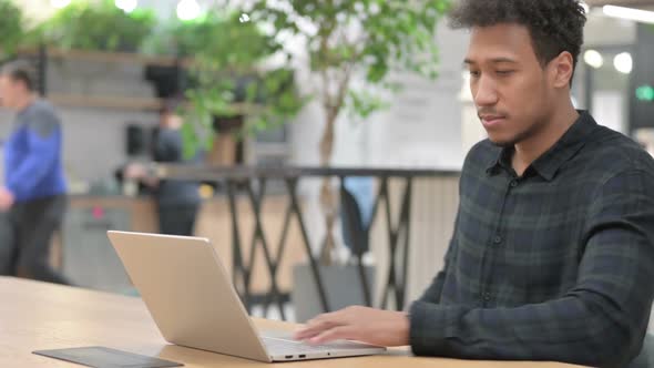 African American Man Closing Laptop Going Away From Office