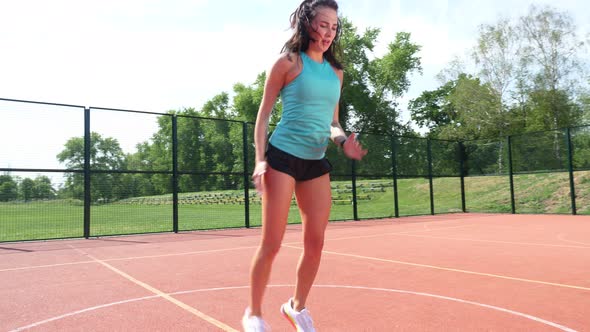 Fitness Woman in Sportswear Doing Various Exercises on an Orange Basketball Field with White