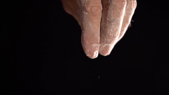 Pour Flour From a Man's Hand on a Black Background