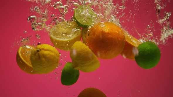 Mix of Exotic Citrus Fruits Falling Into Water in Slow Motion  Orange Lime Grapefruit Lemon