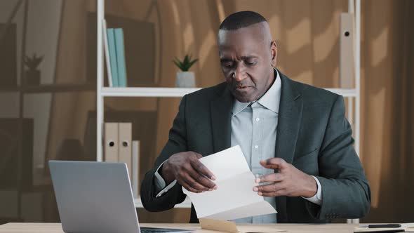 African Old Man Senior Mature Male in Office Opening Paper Envelope Reading Letter with Good News