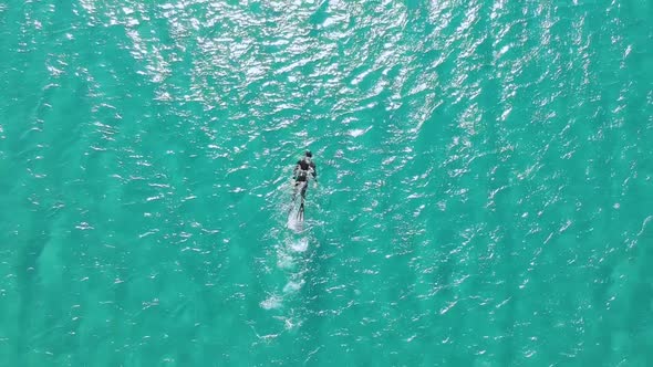 Aerial View of Diver Swimming in Sunlight Shimmering Sea Water