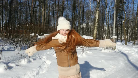 Redhead Teenage Girl, Child Having Fun On Winter Walk. Happy Teen Girl Spinning In Winter Park