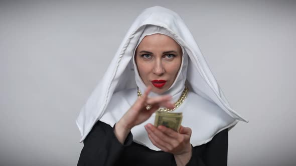 Gorgeous Woman in Nun Costume Scattering Money in Slow Motion Crossing Hands Looking at Camera