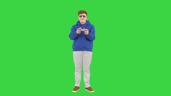 Teenage Boy Playing Videogames and Winning on a Green Screen, Chroma Key.