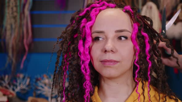 Unrecognizable Person Makes Curly Hairstyle for Young Woman in Salon