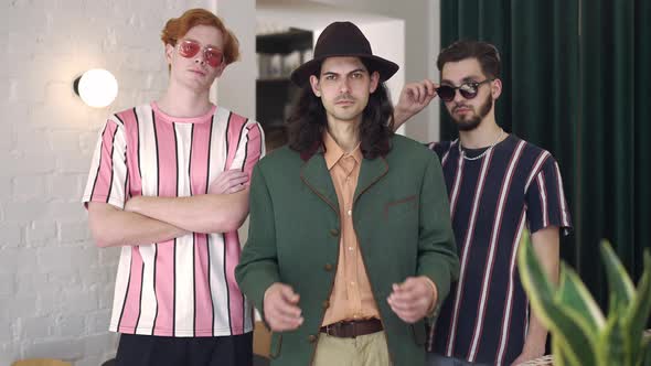 Portrait of Three Stylish Retro Men Standing Indoors Looking at Camera with Confident Facial