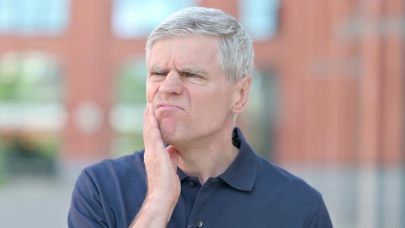 Outdoor Portrait of Sick Middle Aged Man Having Toothache