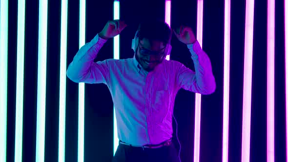 Portrait of a Young Stylish African American Male Wearing Big White Headphones Smiling, Dancing