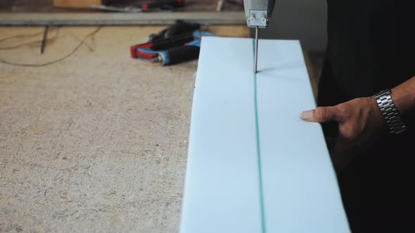 Closeup Hand Male Worker Cutting Foam Rubber for the Production of a Sofa in a Furniture Factory