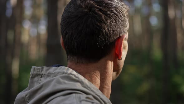 Closeup Side View Caucasian Man in Sunshine Looking Around Standing in Spring Summer Forest