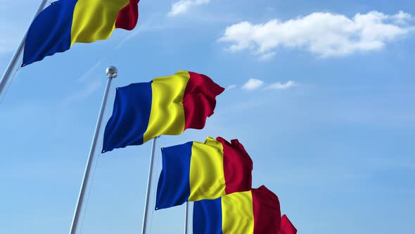 Row of Waving Flags of Romania Agaist Blue Sky