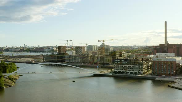 Aerial, rising, drone shot overlooking the Isoisansilta bridge, the Kalasatama and cranes building n