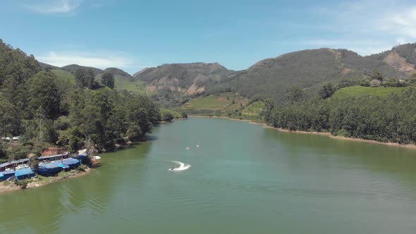 Jet skiing on the shore of Mattupetty Lake near Munnar, overlooked by mountainous landscape in India