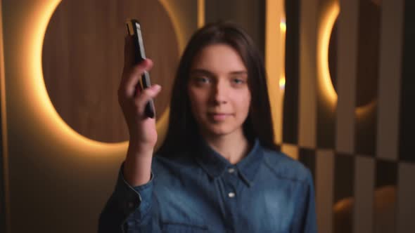 Portrait of Pretty Smiling Caucasian Businesswoman Showing Smartphone with Green Screen Chromakey at