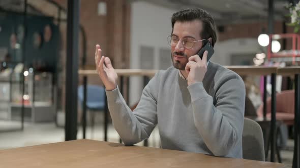 Young Man Talking on Smartphone in Office