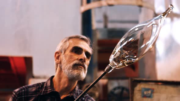 Glassblower shaping a molten glass