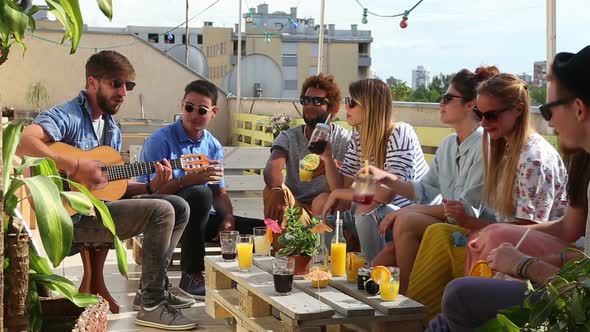 Young friends enjoying at party on rooftop terrace