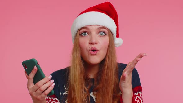 Woman in Stylish Christmas Sweater Looking Smartphone Display Sincerely Rejoicing Win Success Luck