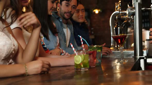 Bartender serving cocktail at bar counter