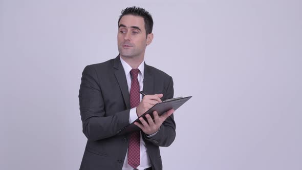 Handsome Businessman Writing on Clipboard