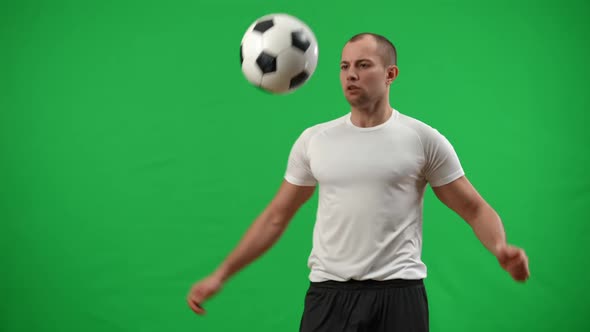 Concentrated Inspired Caucasian Football Player Catching Ball with Chest Juggling with Legs in Slow