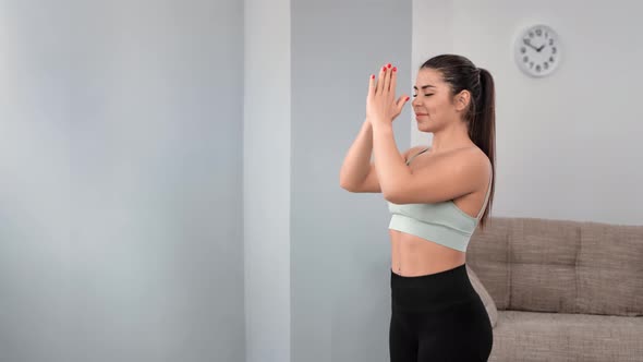 Calmness Young Woman Practicing Yoga Breathing Raising Hands Performing Pilates Exercising at Home