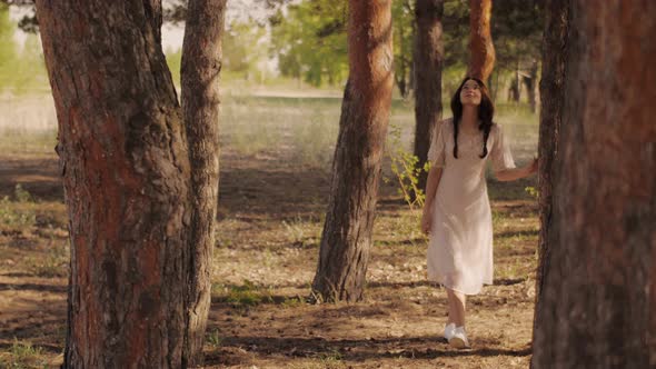 Happy Woman in Forest Enjoying Nature. Cute Young Girl Walking Outdoors