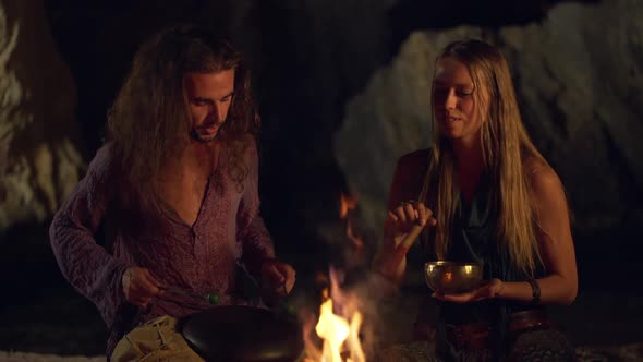 Friends Speaking Smiling Playing on Instruments Sitting Near Bonfire at Night Beach