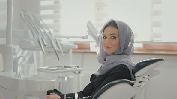 Beautiful Girl With Scarf On His Head Sitting To Dentists Chair