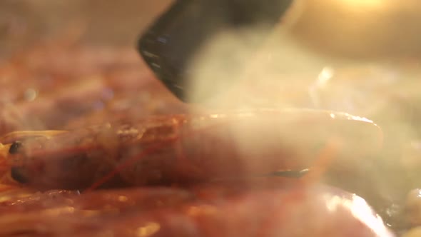 Detail shot of how the prawns are turned while preparing a paella