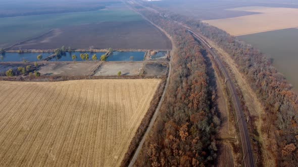 Panoramic Moving Freight Train Along Railway Tracks Trees Agricultural Fields