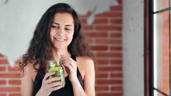 Medium Closeup Portrait of Beautiful Mixed Race Athletic Woman Drinking Healthy Beverage