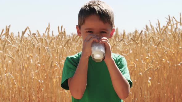 Happy Boy Drinking Milk in the Background of Nature. Healthy Food.