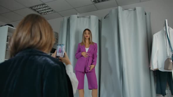 Woman Trying on Clothes and Friend Taking Picture