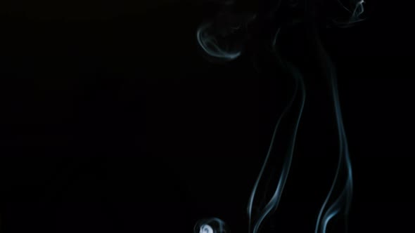 Incense Smoke Curled Up on a Black Background