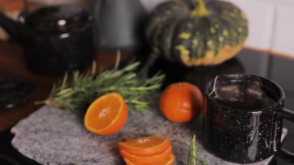 Hot orange tea infusion in a cup close up, organic citrus naturopathy drink with selective focus bac